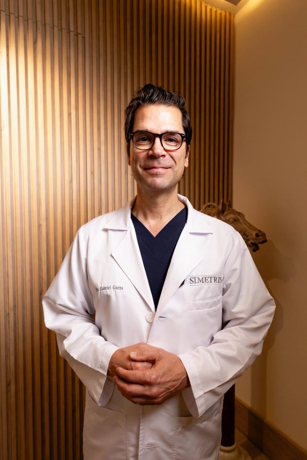 Dr. Gabriel Garza en Simetris, con la bata de su clínica